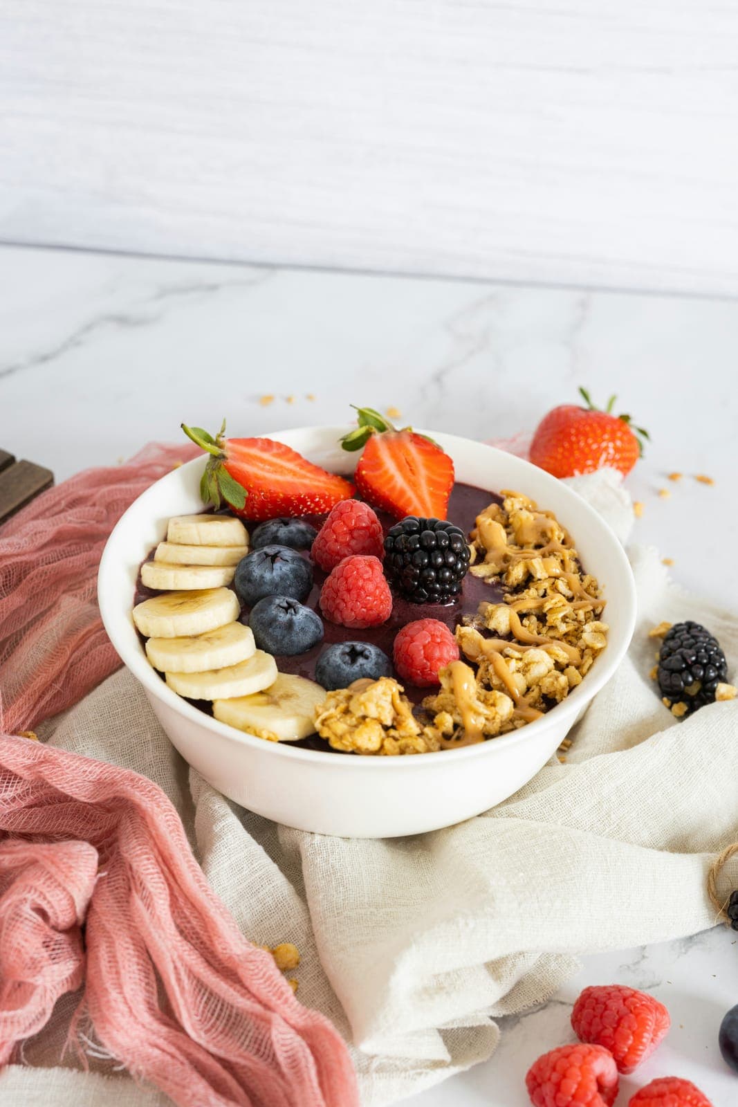 Açaí bowl topped with banana, berries, granola and peanut butter